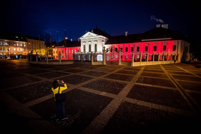 斯洛文尼亚总统府周二在外墙点亮红白灯，象征奥地利国旗颜色，向罹难者致意。（法新社）