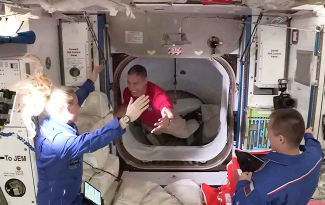 “龙飞船”里的4名太空人打开舱门，进入国际空间站，站里的3名成员迎接他们。（美联社）