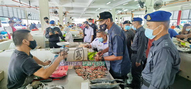罗索华希（右2）向峇株巴辖公市一名业者了解鲜虾价格。