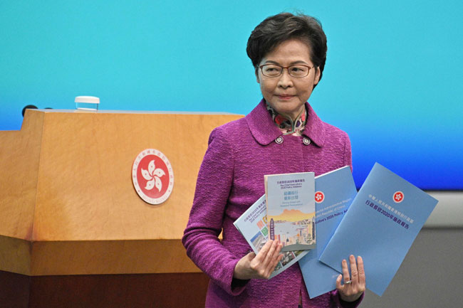 林郑月娥周三在香港政府总部召开记者会，并手持施政报告。今年的施政报告封面将继续采用天蓝色，冀为香港带来希望。（法新社）