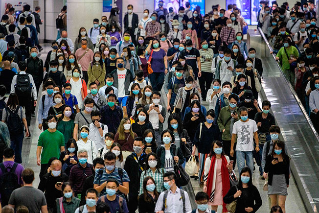 周三在香港一地铁站，可见民众戴口罩，人群相当多。（法新社）