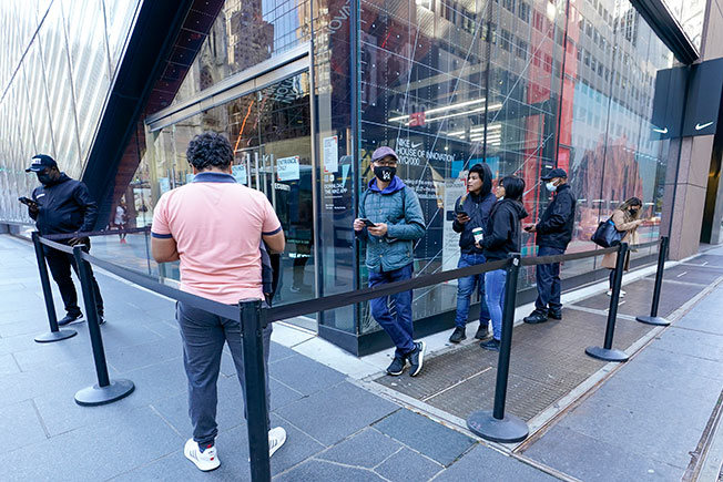 寥寥无几的民众，周五在纽约第五大街的耐克商店外排队等待进入商店购物。（美联社）