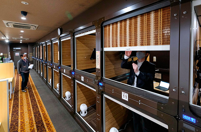 应对疫情打击，日本新宿一家胶囊旅馆将房间隔墙拆除，改装变成共用工作空间。（法新社）
