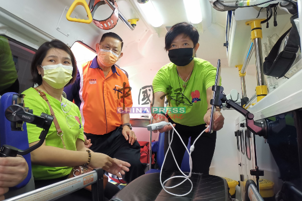 苏蕤丽（右）将超音波扫描仪器安装在救伤车上。左起为陈耐遆及黄循霖。