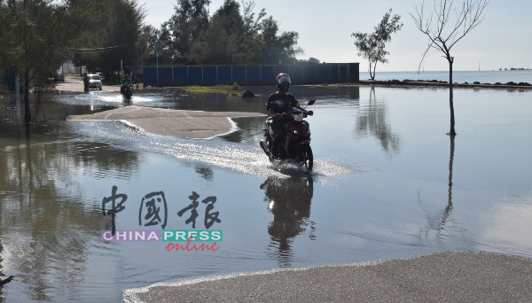 居民骑摩哆涉水而过。