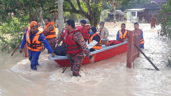 消拯员及民防局队员使用船只，把受困在甘榜牙力灾区的灾黎救出。