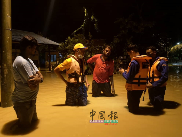 甲民防部队队员到灾区援助水灾灾民。