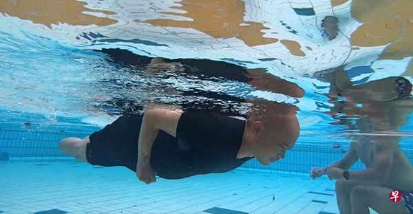 龙籍盛虽然失去了双腿和手指，但仍勇于重回泳池，接受分段游一公里的挑战。（联合早报、SAFRA提供）  