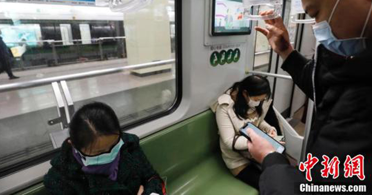 上海民众在地铁车厢看手机。