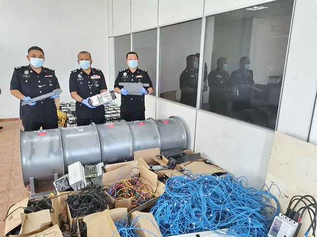 马祖基(中)、吉辇刑事调查主任陈木华(右)和警官,展示所起获的电线、路由器、挖矿机等。