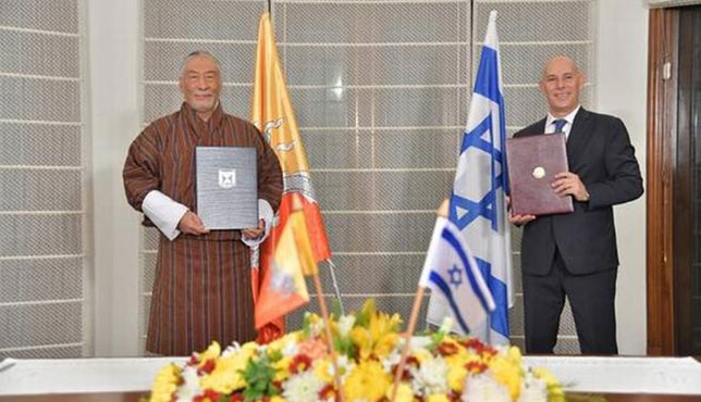 不丹和以色列驻印度大使维索普·纳姆吉尔少将（左）及马利卡12日在新德里的以色列大使馆展示已签署的建交协议。