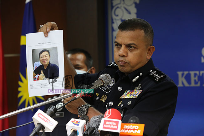 阿育甘展示警方通缉涉案头目陈金文。