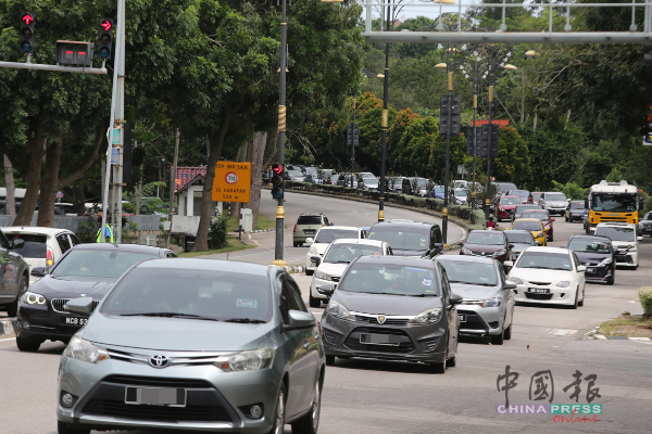 靠近爱极乐班台医院的红绿灯路口出现大量车辆，大家都是往市区方向前进。