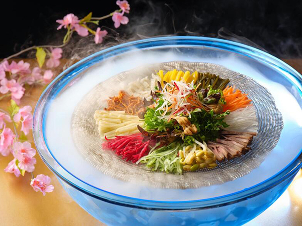 四川豆花饭庄用萤光盆转动捞鱼生，象征扭转乾坤。（受访者提供）