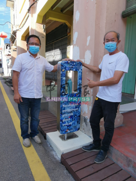 豆腐街设有世遗区第一台免费公用饮水机，鼓励民众续杯装水，减少丢弃塑料瓶。左起为张伟霖及罗联轩。