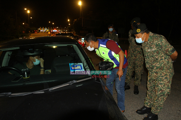 嘉马鲁丁（右起）及聂哈林检查进入马六甲的车辆。