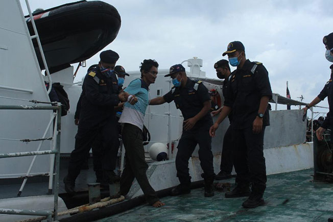 获救渔民在海事执法机构官员扶助下登岸。