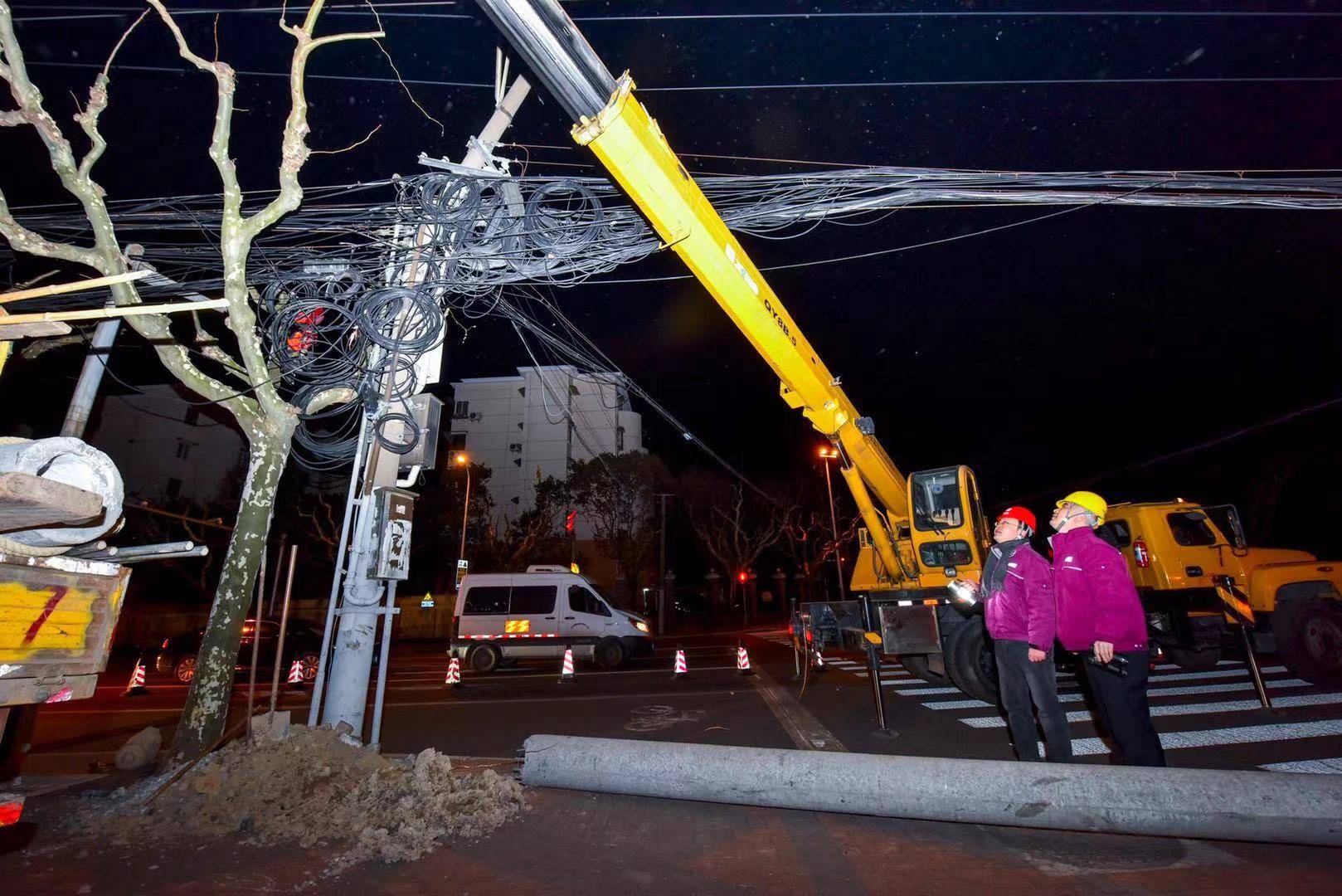 有电力公司员工在上海一社区抢修电缆。