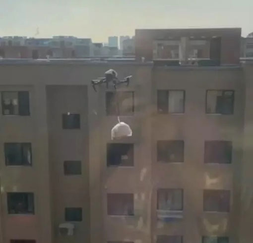 被隔离的高楼屋主用无人机吊挂垃圾袋飞往户外“丢垃圾”。（微博）