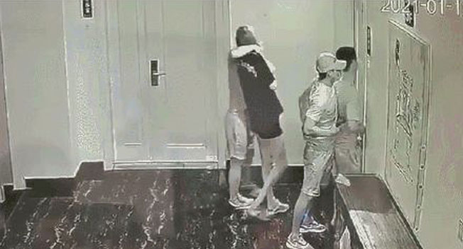 萧波和女友曹某被胁持到一处公寓单位画面。可见戴鸭嘴帽男子用枪指着萧波的背后。
