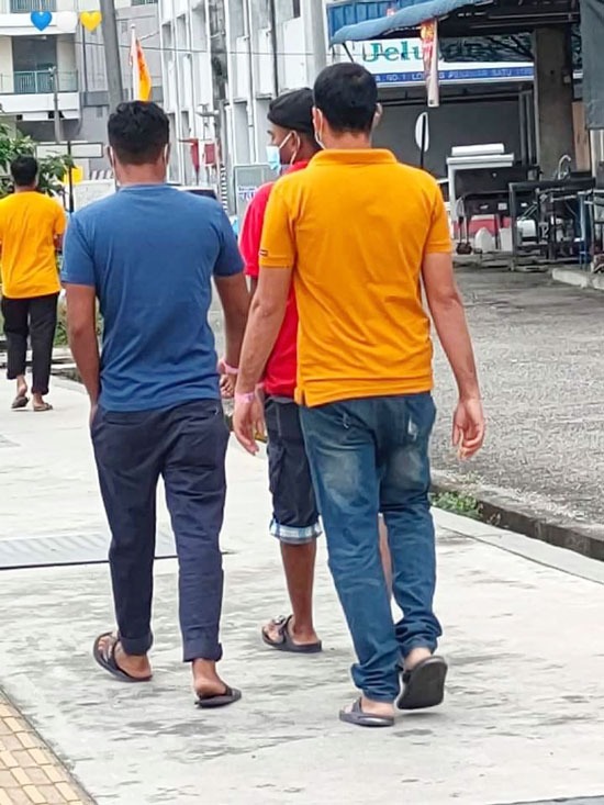根据Penang Kini，数名戴着粉红色手环的男子，被拍到在外走动，但后来证实，有关男子正步行返家隔离。（取自Penang Kini）