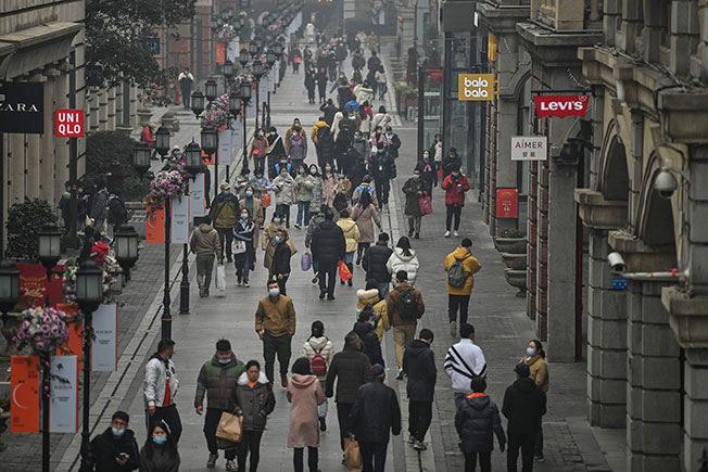 人群23日在武汉的一条步行街上行走逛街。（法新社）