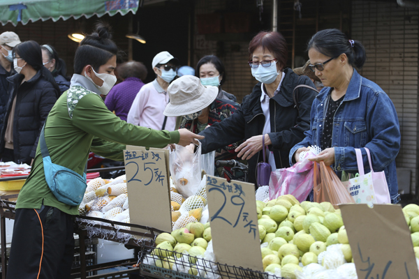 周一在台北菜市，小贩戴口罩防疫。