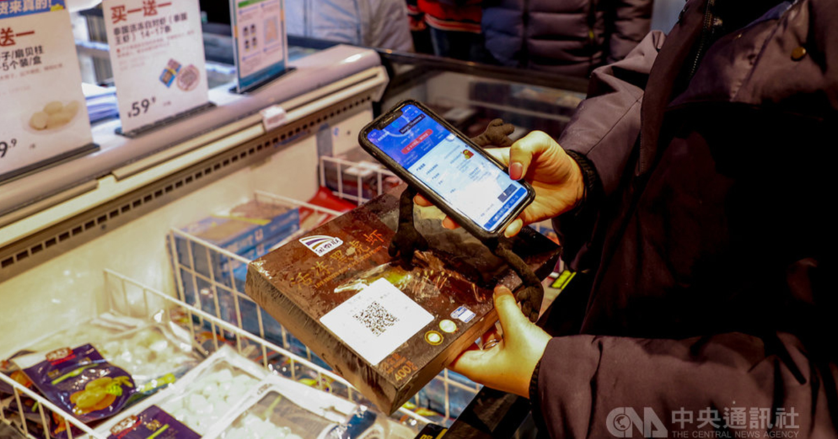 湖北武汉市一间超市，消费者用手机扫码查看一盒进口冷冻鲜虾的检测资讯。