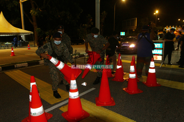军人协助警方设立路障。