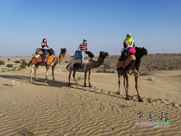 包头蒙脸骑骆驼阻挡烈日，数小时横跨沙漠扎营之地。