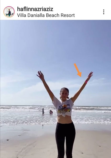 哈菲琳戴着粉红色隔离手环（箭头所指）到海边嬉水，被指违反隔离令，但她以“我的私人海滩”反驳指责。