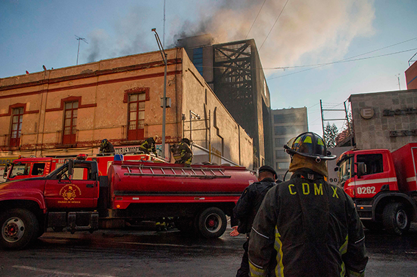 火灾发生后，消防车抵达现场展开搜救和灭火工作。（法新社）