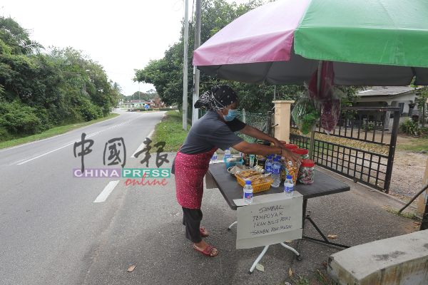 居住在甘榜的民众暂时在住家门外经营小本生意，赚取微薄收入。