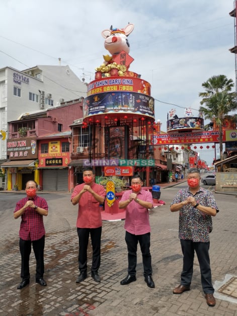 李传财（左起）、郑国球、颜天禄及蔡永泉为“开运牛”吉祥物挂上红绫。