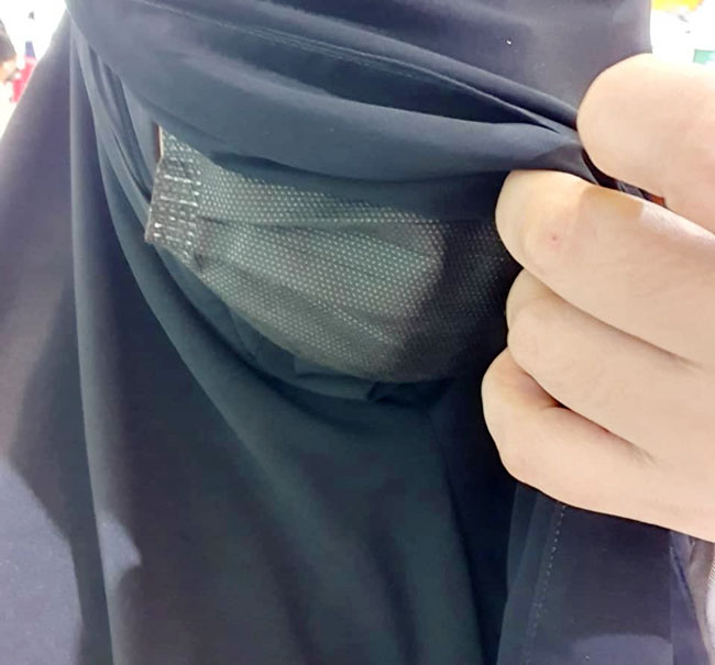 马来妇女亚沙里说，每当被安全距离大使或在扫码登录Safe Entry被询问时，她都会这样拉开面纱向对方确认自己有戴口罩。（取自面书）
