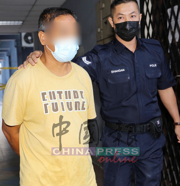 身穿黄衣的被告，被警员押抵达地庭提控。