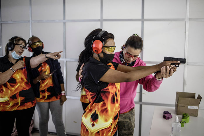 女性射击培训班的学员，由导师指点枪法。（法新社）