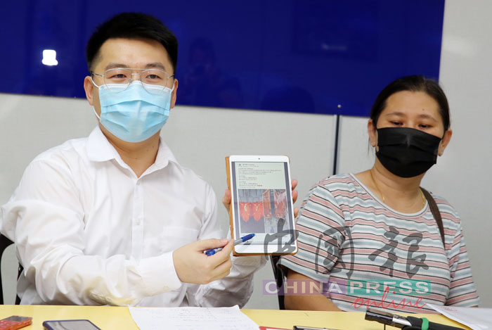 刘国南（左）与冯嘉玲展示网上骗局详情。