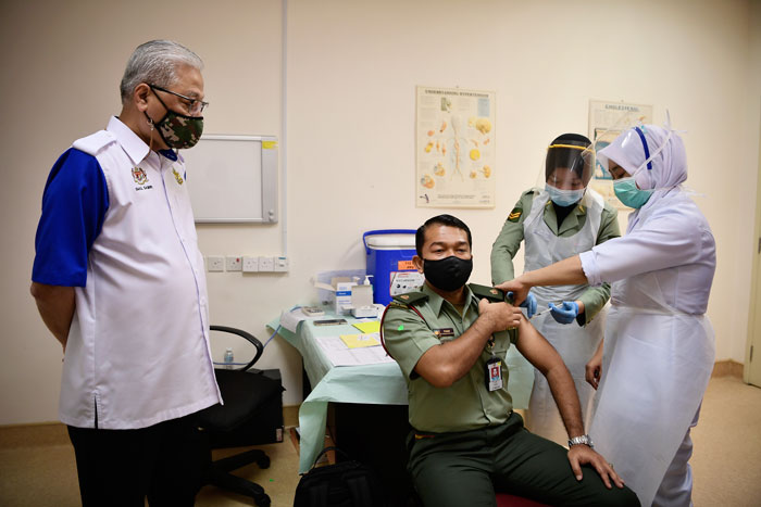 依斯迈沙比里（左）巡视端姑米占武装部队医院进行的疫苗接种工作。