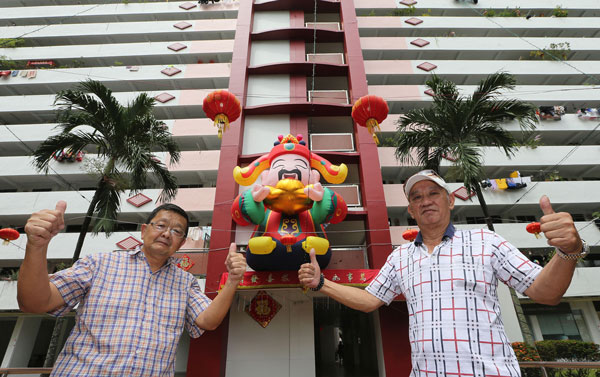 王昌明（左）、陈忠明等3个居民提前一个月为组屋布置新年装饰。（唐家鸿摄）