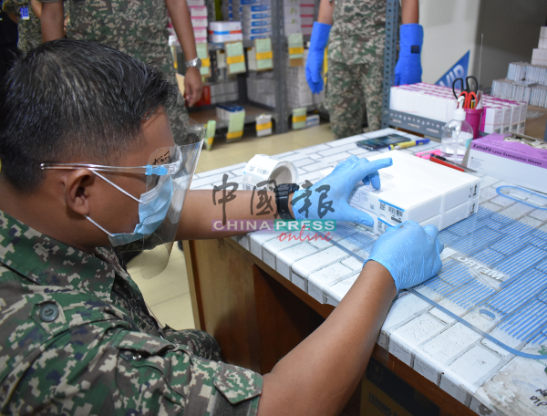 军官为刚接领的新冠肺炎疫苗贴上标记。