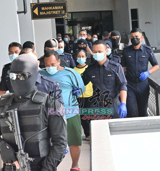 男被告莫哈末法兹里（左2起）及祖莱达阿丹被大批警员押出法庭时，目无表情。