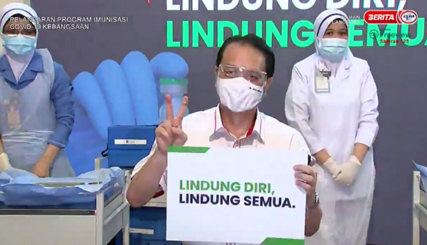 山哥在接种后，比出胜利手势。