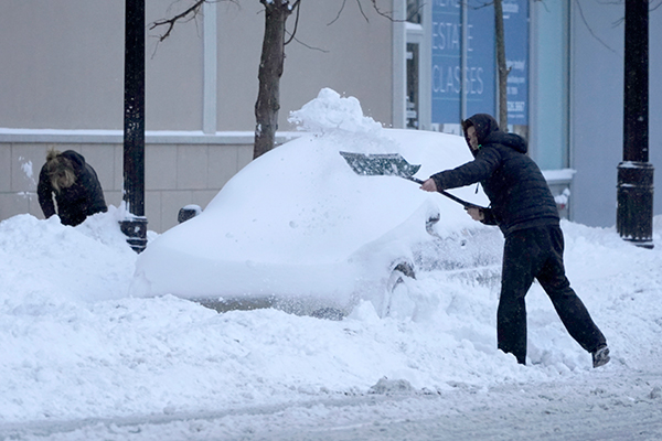 2名男子在芝加哥举起铲子清理积雪。（美联社）
