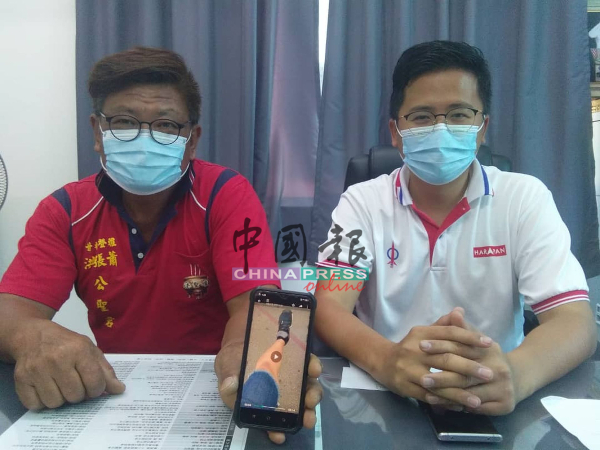 陈顺华（左）向谢守钦申诉穿着长至膝盖裤子，却被拒绝进入马六甲城市转型中心。