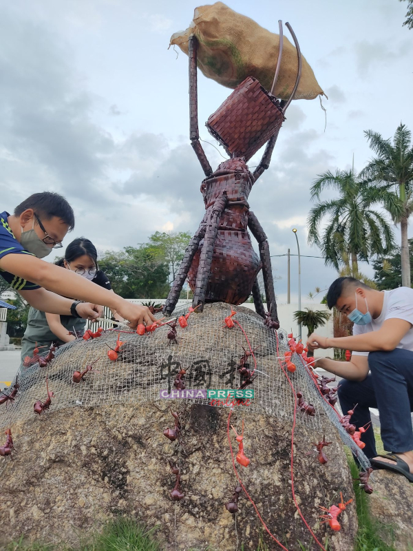 志工们进行最后的加工，以完成“蚂蚁搬米萝”。