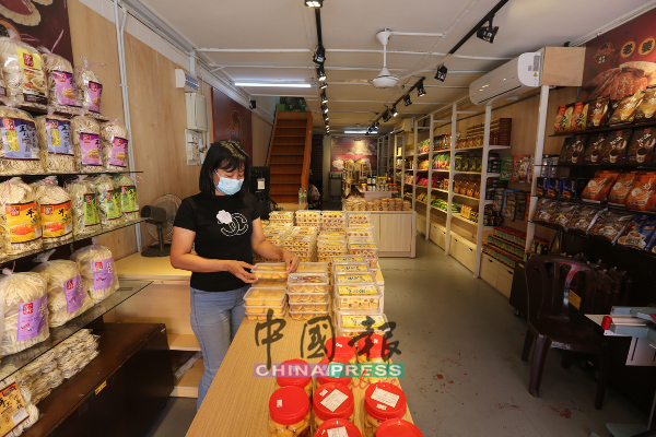 七里香百年饼家在新年期间照常营业，惟几乎没顾客光顾，职员亚波只好忙于整理货物。