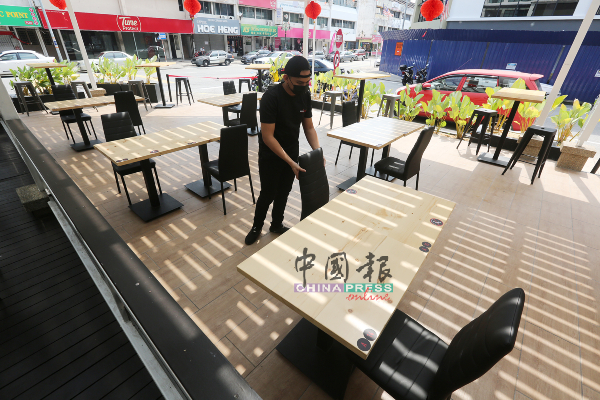 餐厅职员为每张桌子排好两张椅子，确保不会发生超坐情况。