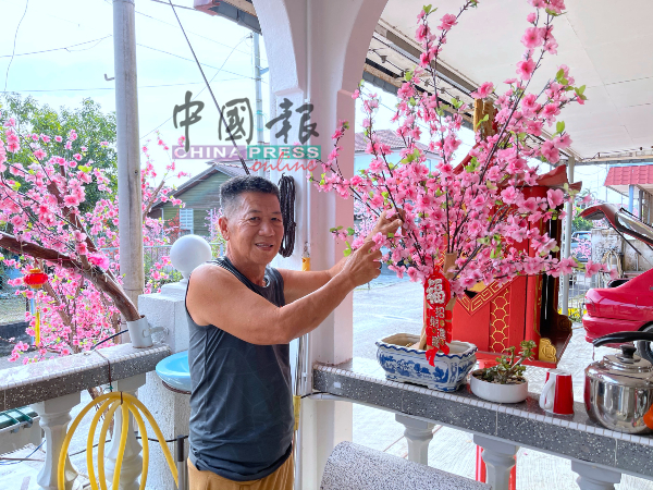 傅协隆为梅花树进行装饰工作。