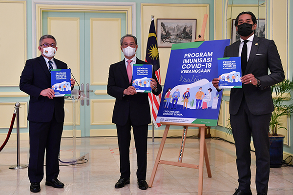 慕尤丁（中）在首相署推介《全国新冠肺炎免疫计划指南》，右起为凯里及阿汉峇峇。